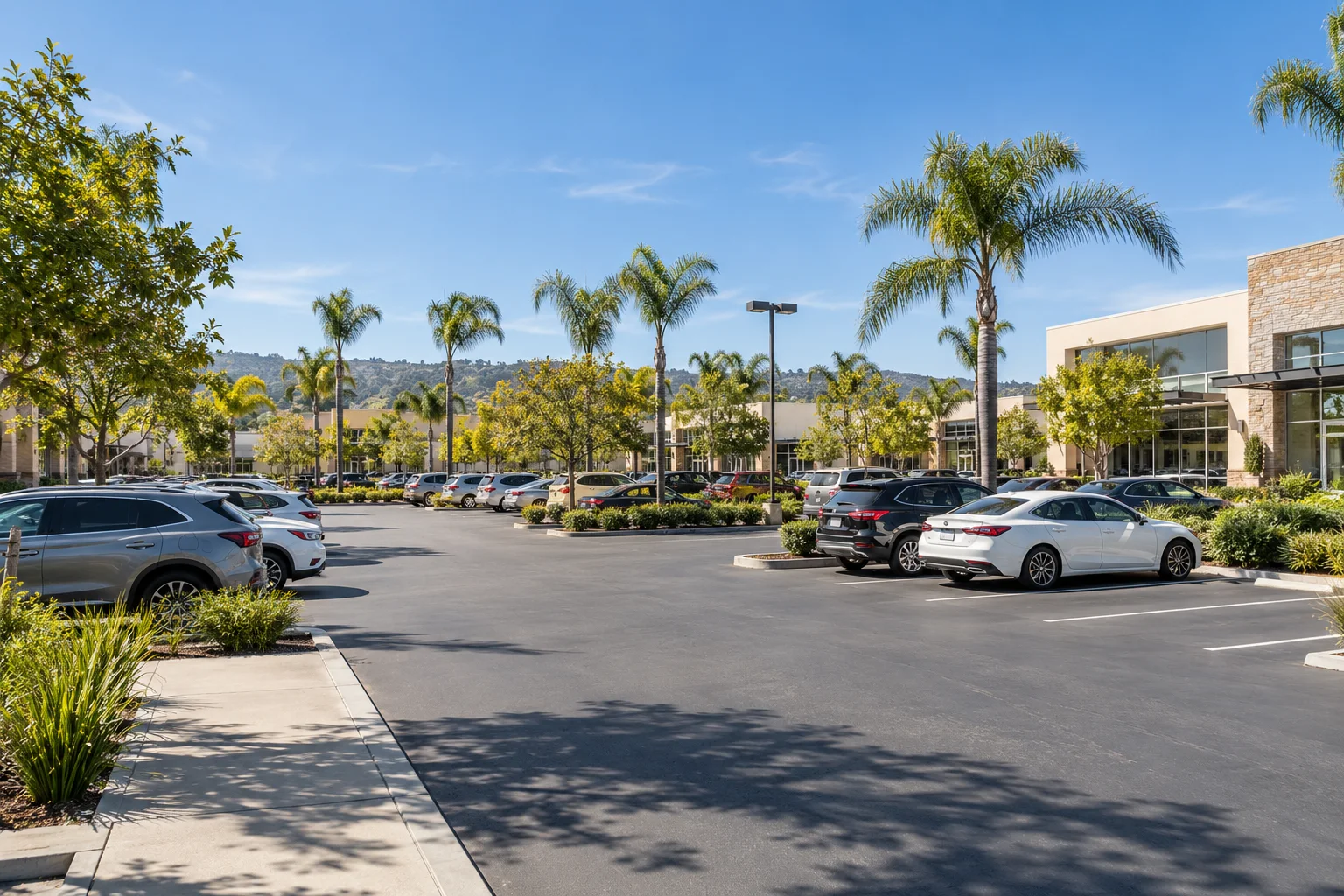 Open-air parking lot beside commercial buildings in Southern California.